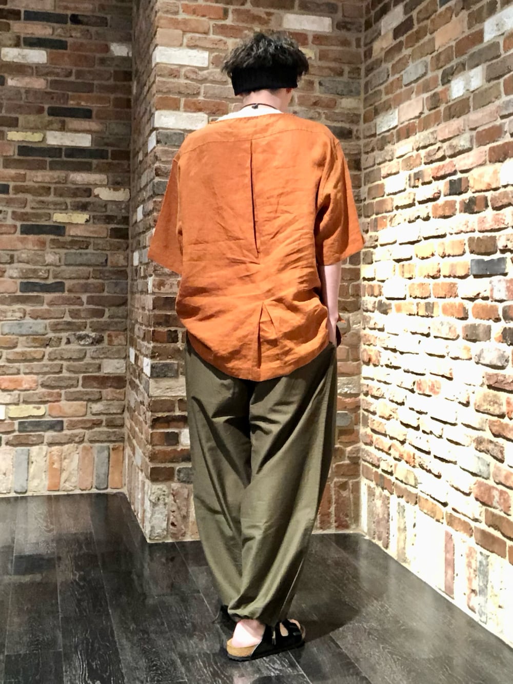 オレンジ系のトップス、グリーン系のその他パンツ、ブラック系のサンダルを着用したメンズの春コーディネートの3枚目の写真