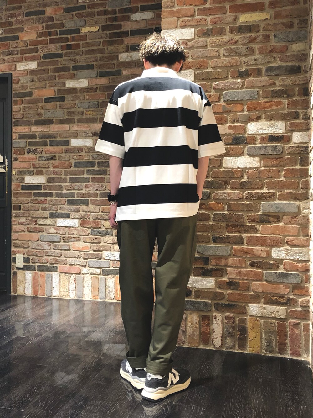 その他のポロシャツ、グリーン系のチノパンツ、グレー系のスニーカーを着用したメンズの春コーディネートの3枚目の写真