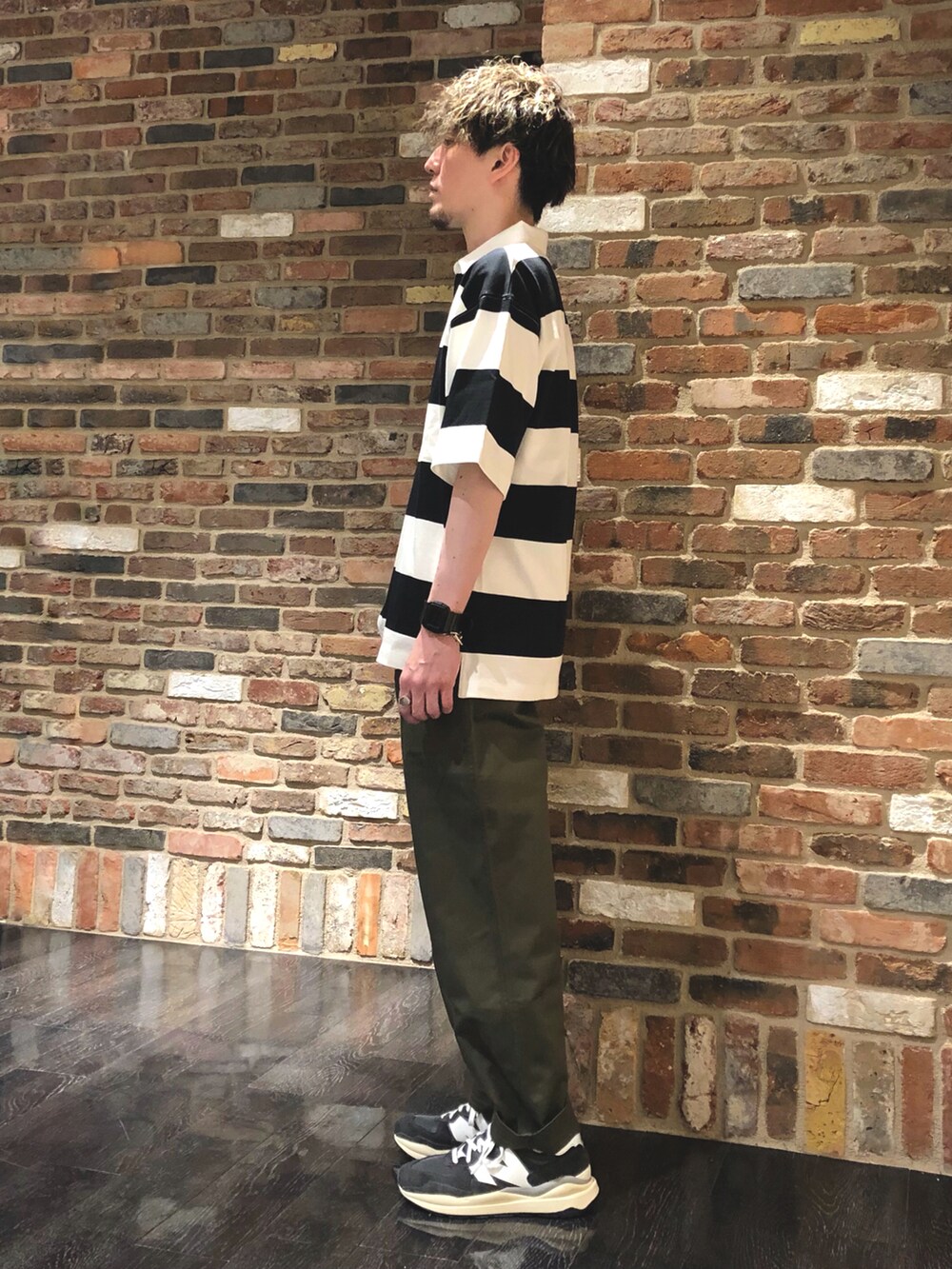 その他のポロシャツ、グリーン系のチノパンツ、グレー系のスニーカーを着用したメンズの春コーディネートの2枚目の写真