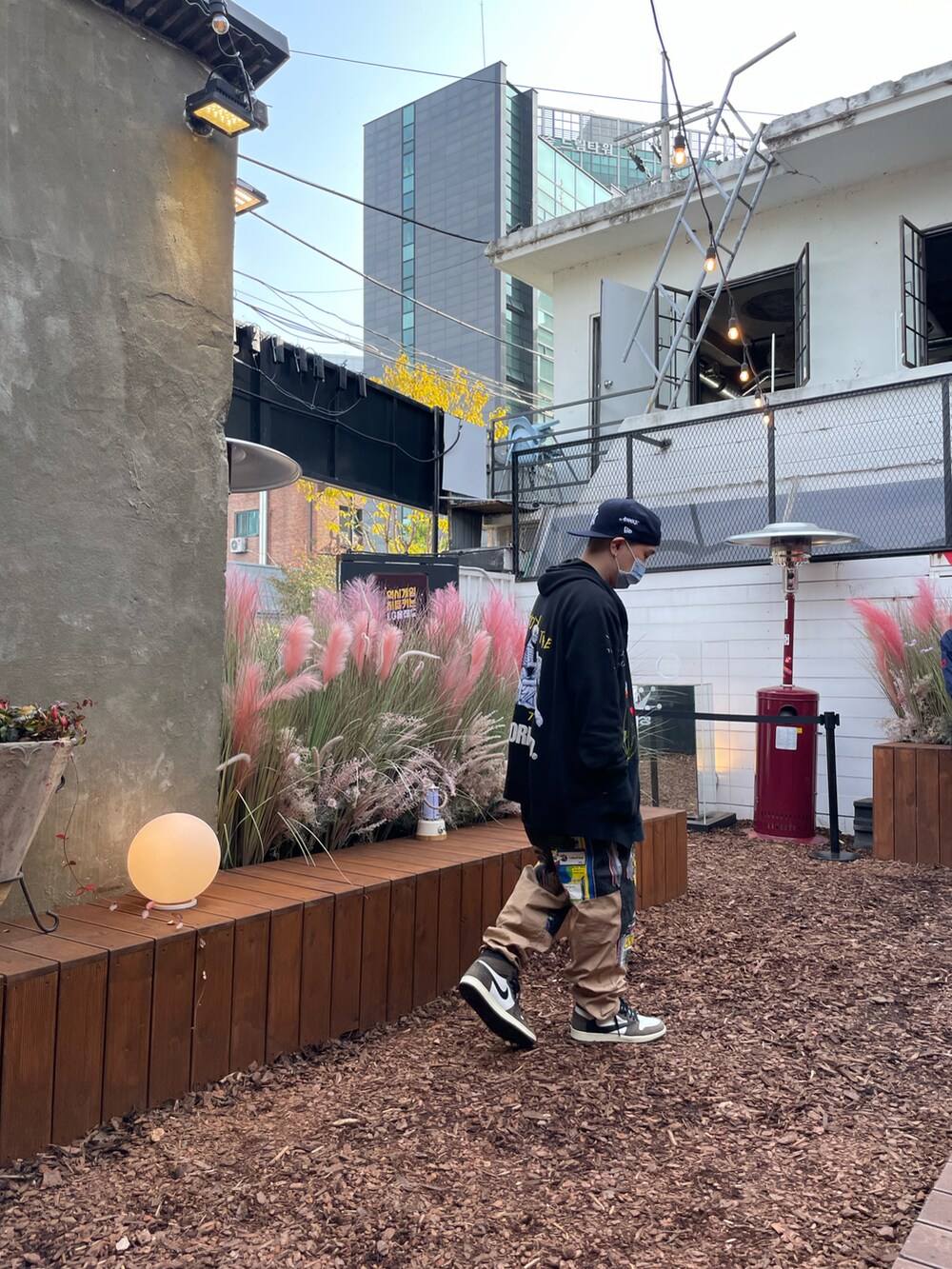 ベージュ系のその他パンツ、ブラウン系のスニーカー、ブラック系のパーカーを着用したメンズの春コーディネートの4枚目の写真