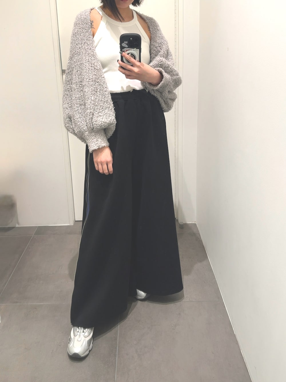 ブラック系のその他パンツ、シルバー系のスニーカー、グレー系のニット/セーターを着用したレディースの秋コーディネートの2枚目の写真