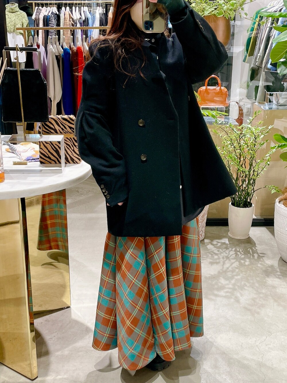 ブラック系のブーツ、グリーン系のスカート、ブラック系のノーカラージャケットを着用したレディースの冬コーディネートの2枚目の写真