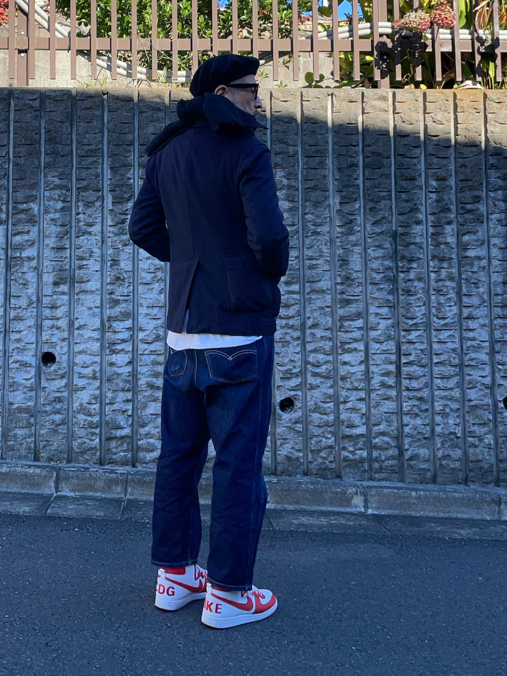 ブルー系のテーラードジャケット、ブルー系のデニムパンツ、ホワイト系のスニーカーを着用したメンズの冬コーディネートの2枚目の写真