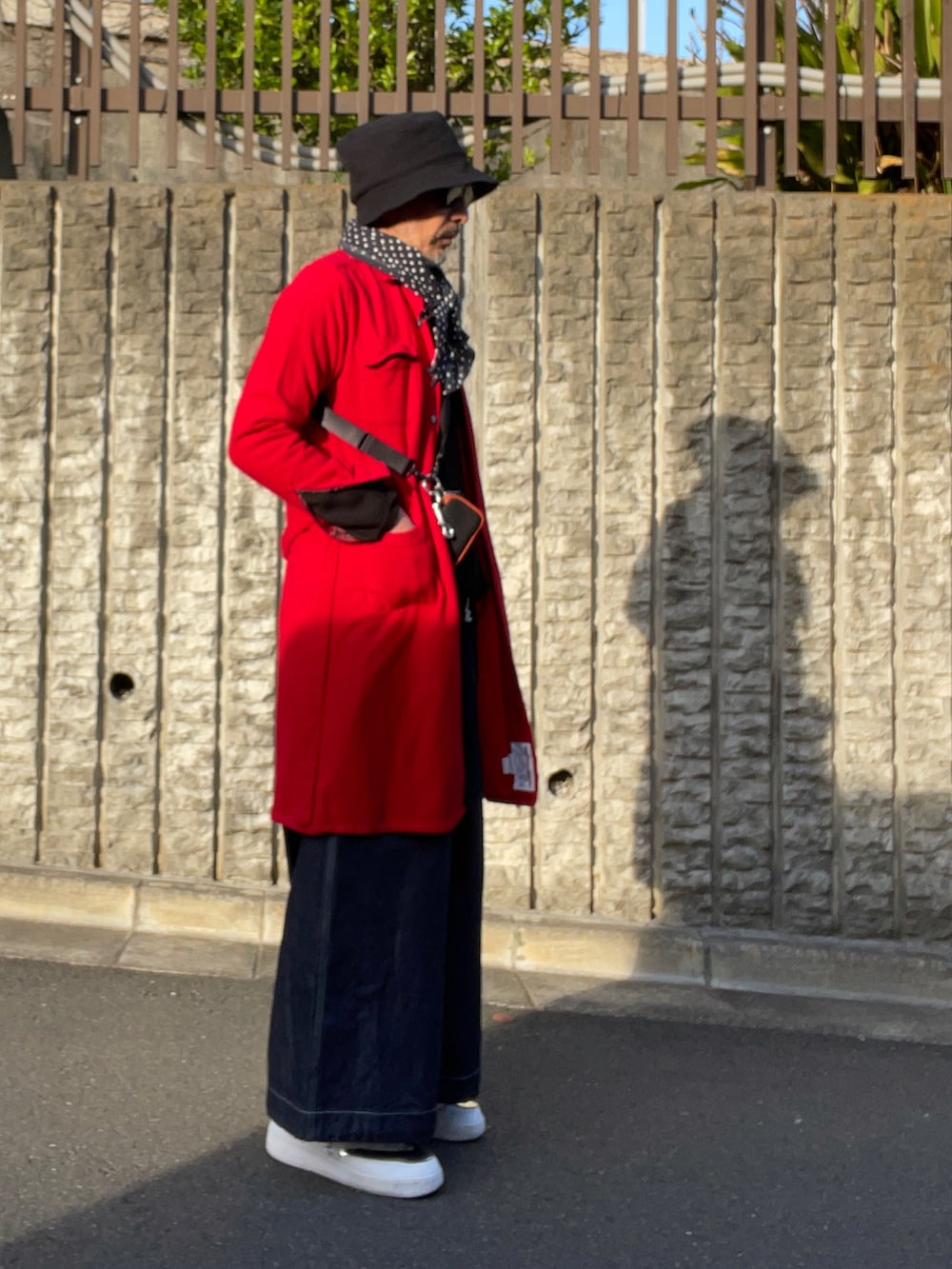 ブルー系のデニムパンツ、ホワイト系のスニーカー、ブルー系のハットを着用したメンズの春コーディネートの2枚目の写真