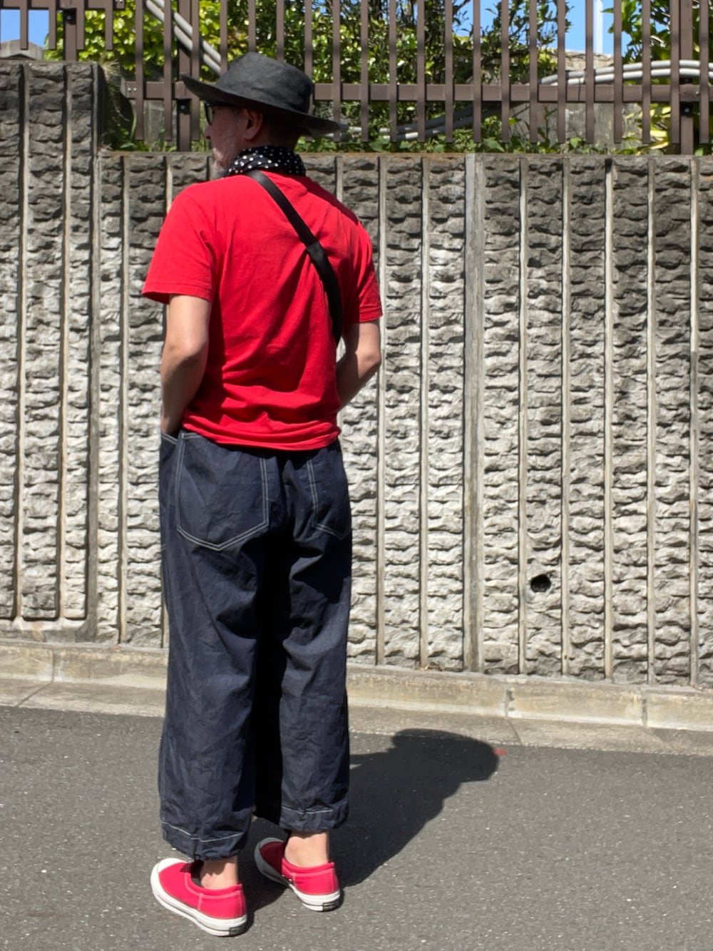 ブルー系のデニムパンツ、ブラック系のハットを着用したメンズの春コーディネートの2枚目の写真