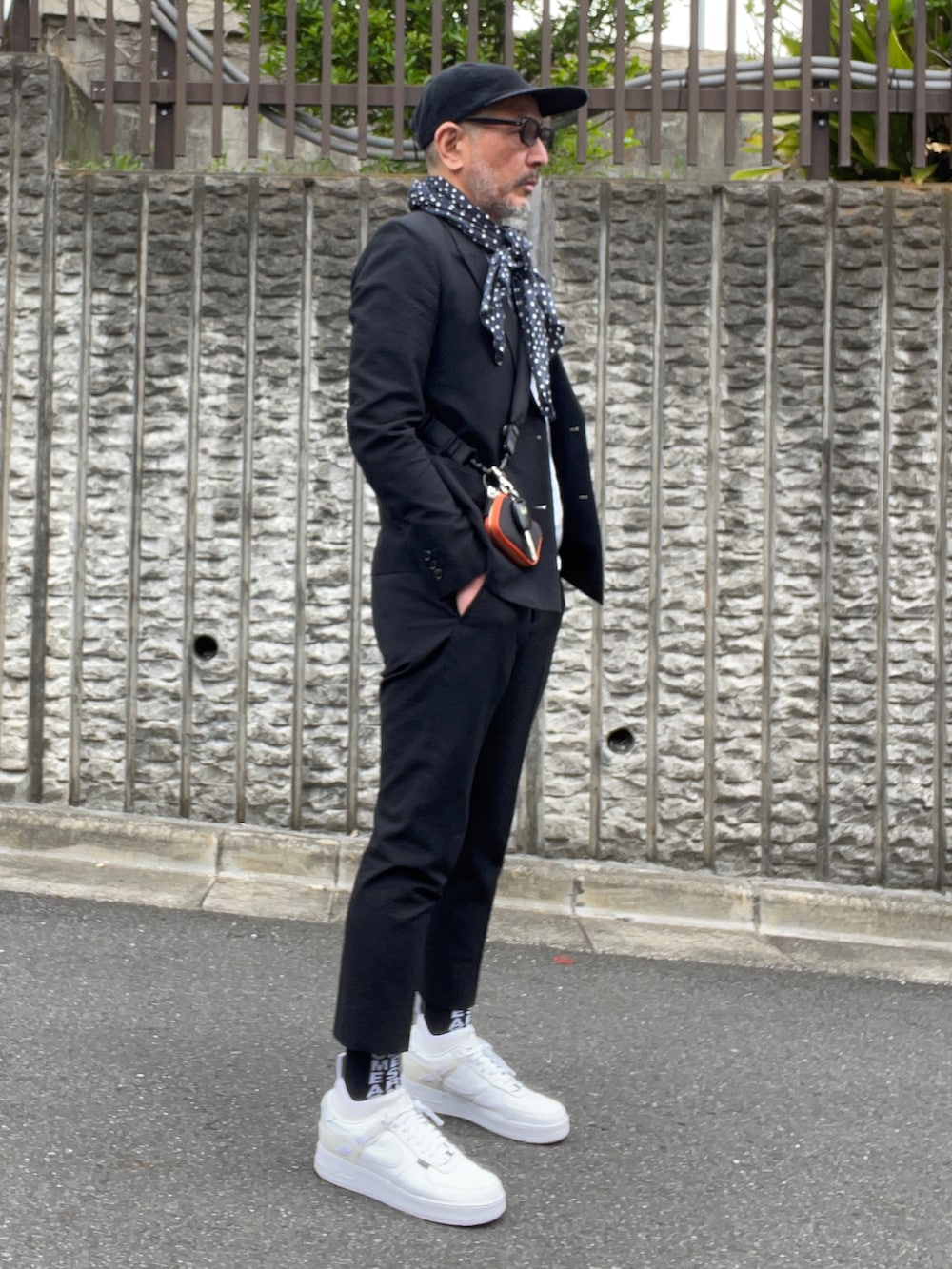 ブラック系のテーラードジャケット、ホワイト系のスニーカー、ブラック系のソックス/靴下を着用したメンズの春コーディネートの3枚目の写真