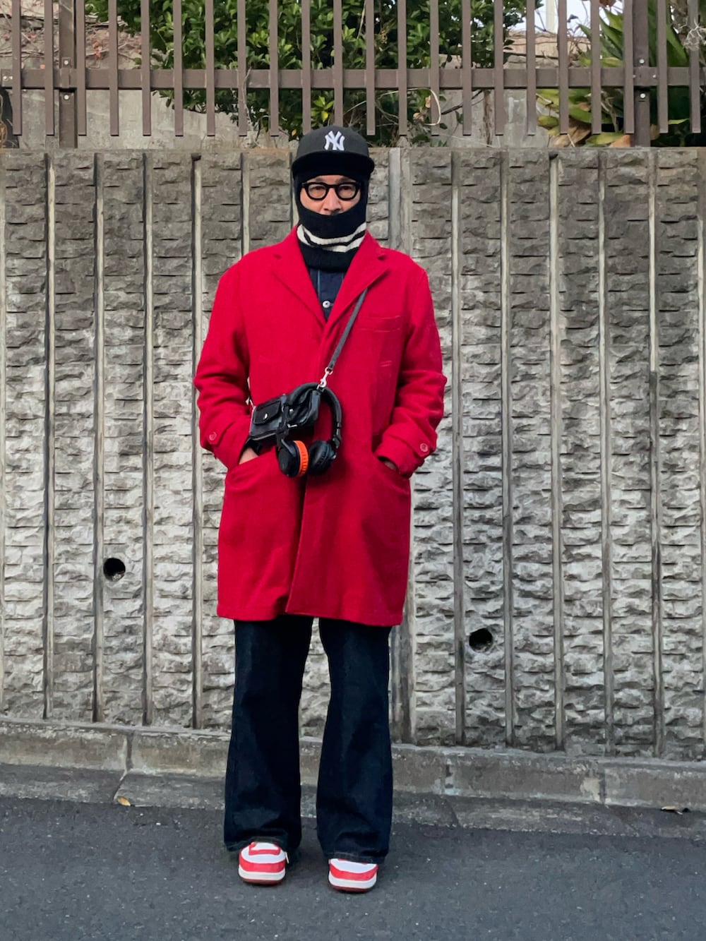 ブルー系のデニムパンツ、ブラック系のボディバッグ/ウエストポーチ、ホワイト系のスニーカーを着用したメンズの冬コーディネートの2枚目の写真