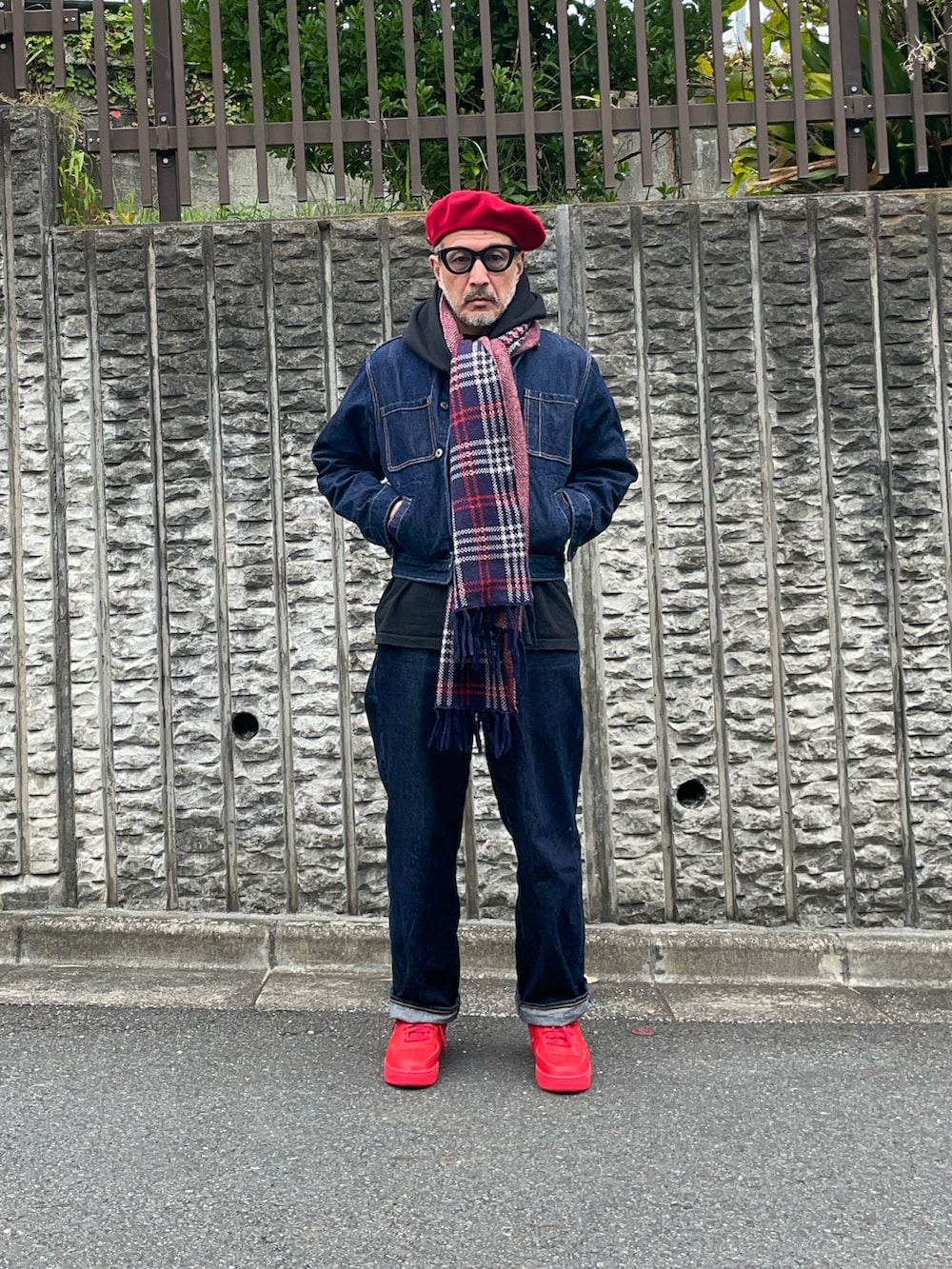 ブルー系のデニムジャケット、ブルー系のデニムパンツ、レッド系のスニーカーを着用したメンズの秋コーディネートの2枚目の写真