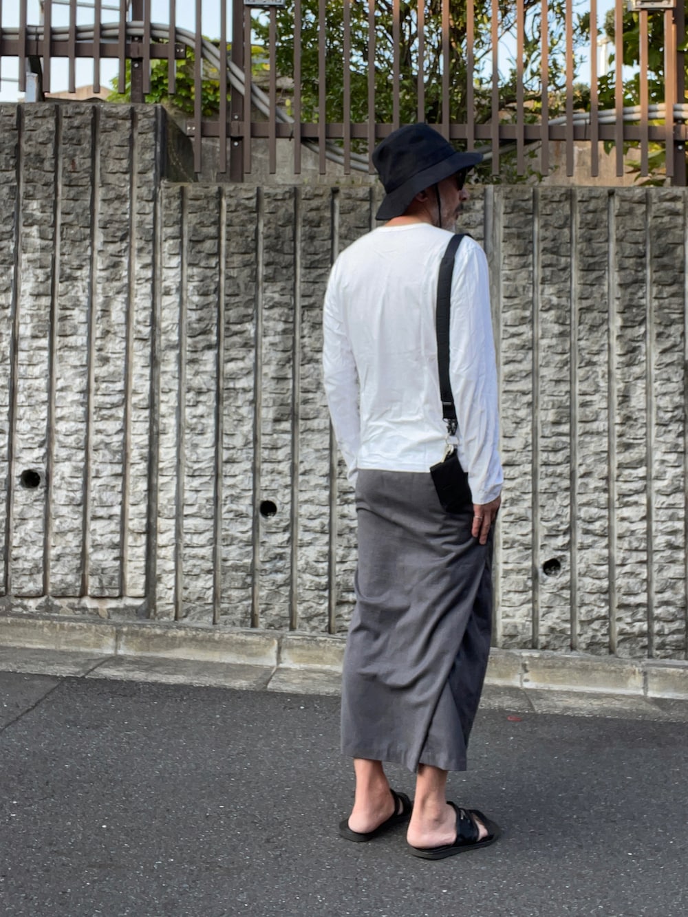 ホワイト系のTシャツ/カットソー、ブラック系のサンダル、グレー系のその他パンツを着用したメンズの夏コーディネートの3枚目の写真