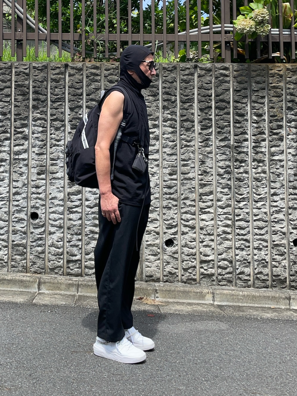 ブラック系のパンツ、ホワイト系のスニーカー、ブラック系のファッション雑貨を着用したメンズの夏コーディネートの2枚目の写真