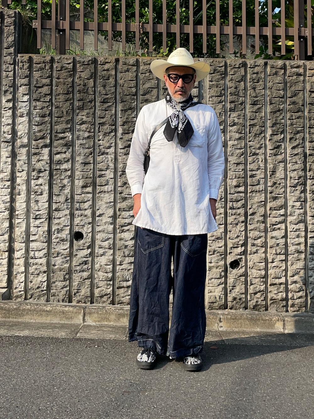 ブルー系のデニムパンツ、ベージュ系のハットを着用したメンズの夏コーディネートの2枚目の写真