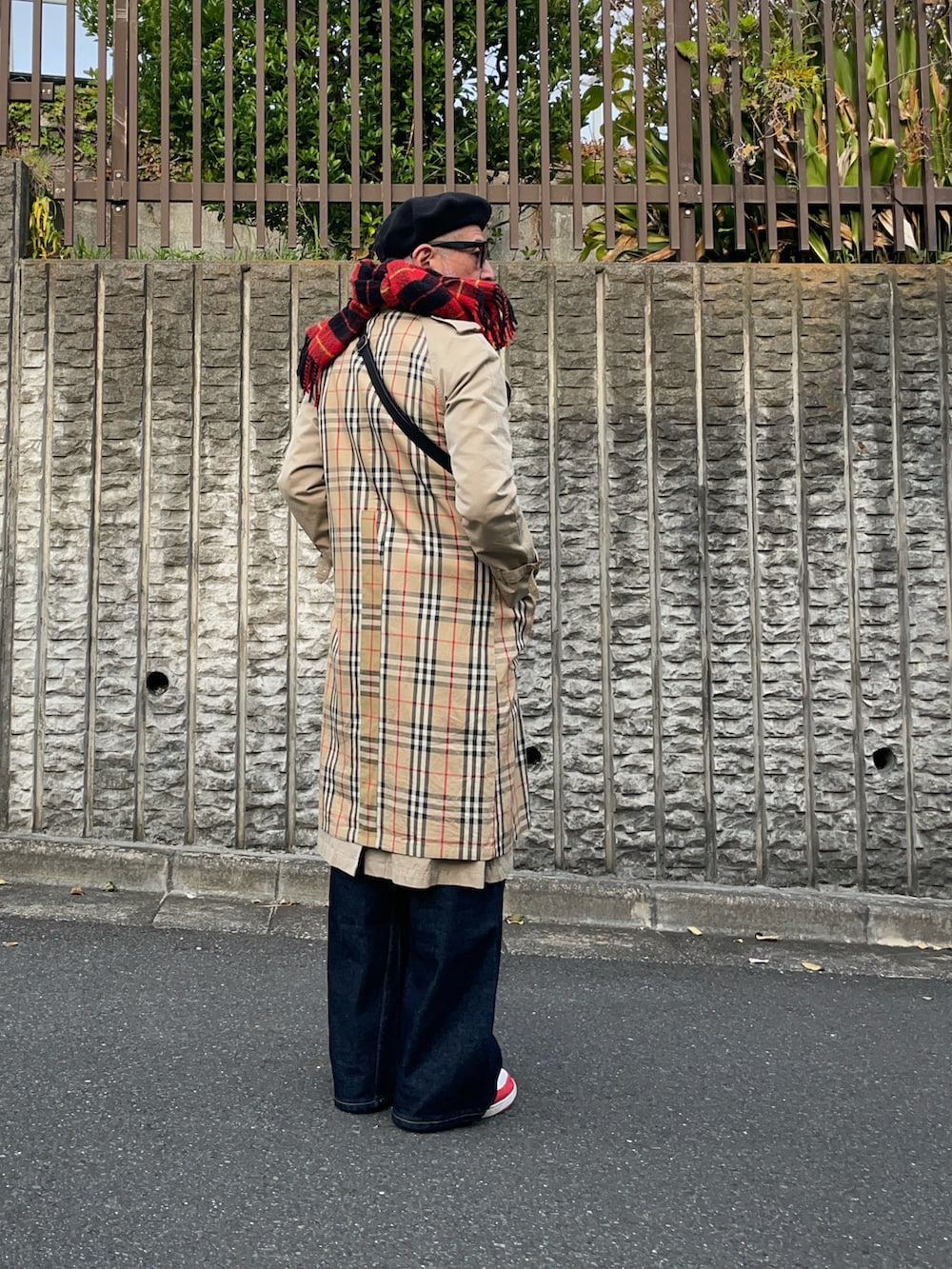 ブルー系のデニムパンツ、レッド系のマフラーを着用したメンズの秋コーディネートの2枚目の写真