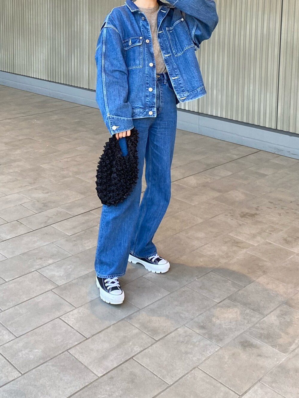 ブルー系のデニムパンツ、ブルー系のセットアップ、ブラック系のスニーカーを着用したレディースの春コーディネートの2枚目の写真