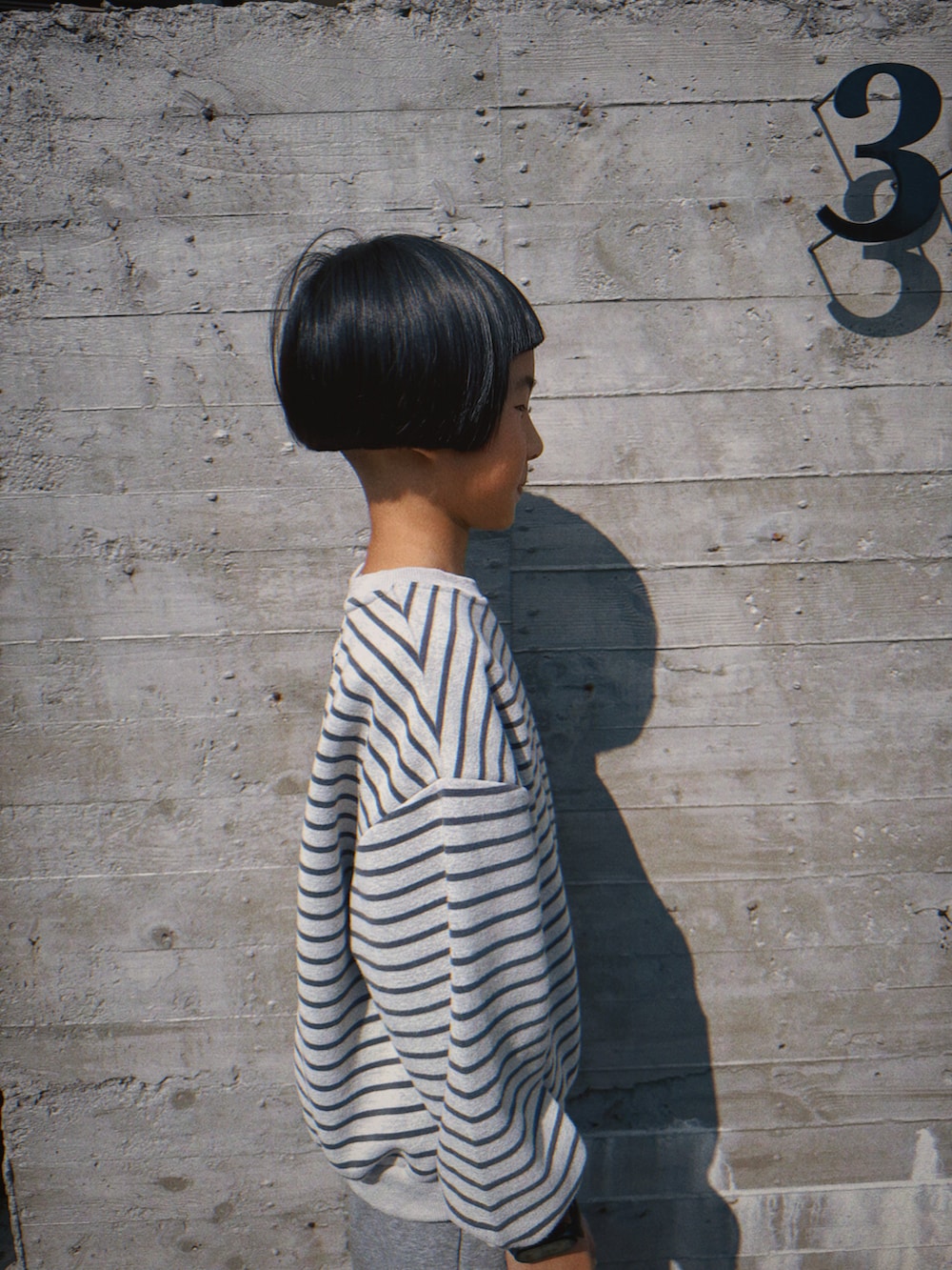 グリーン系のステンカラーコートを着用したキッズの冬コーディネートの4枚目の写真