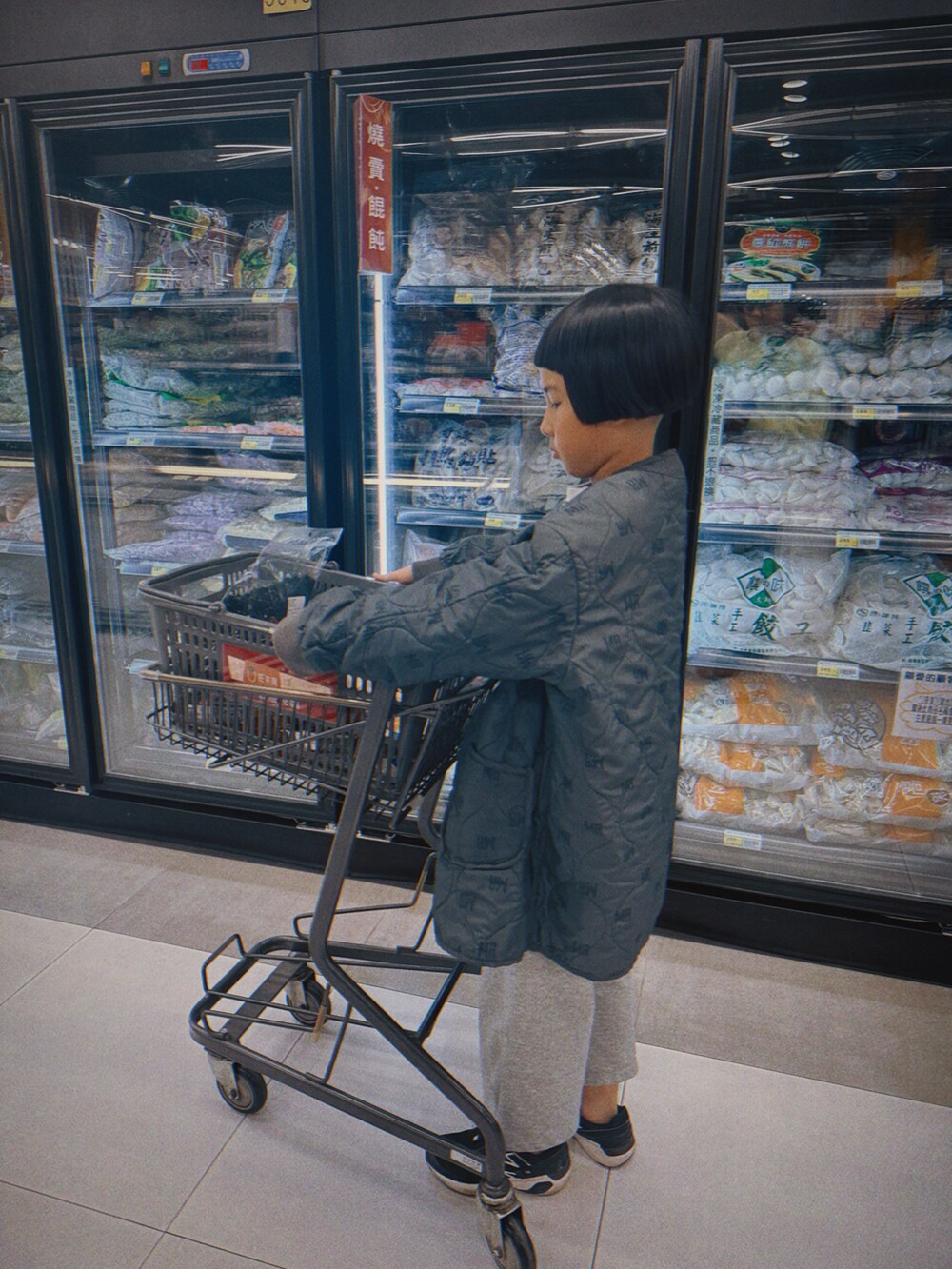 グリーン系のステンカラーコートを着用したキッズの冬コーディネートの2枚目の写真