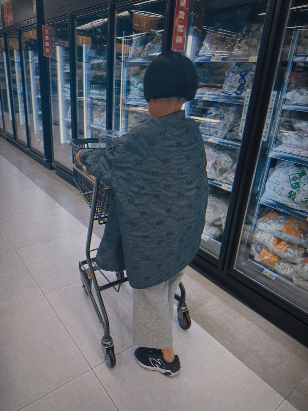 グリーン系のステンカラーコートを着用したキッズの冬コーディネートの3枚目の写真