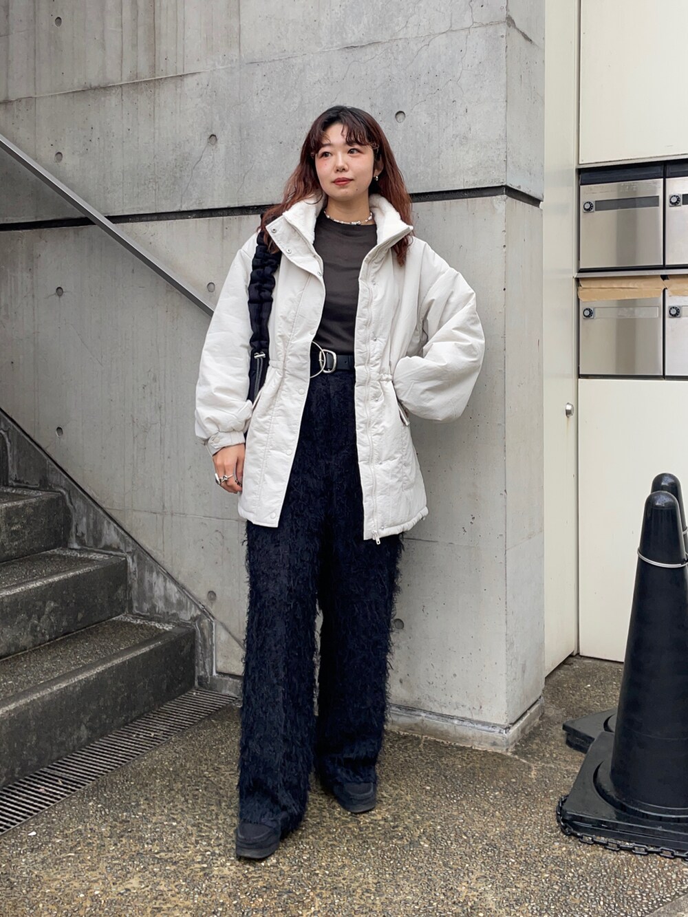 ブラック系のショルダーバッグ、ホワイト系のブルゾン、グレー系のTシャツ/カットソーを着用したレディースの冬コーディネートの5枚目の写真