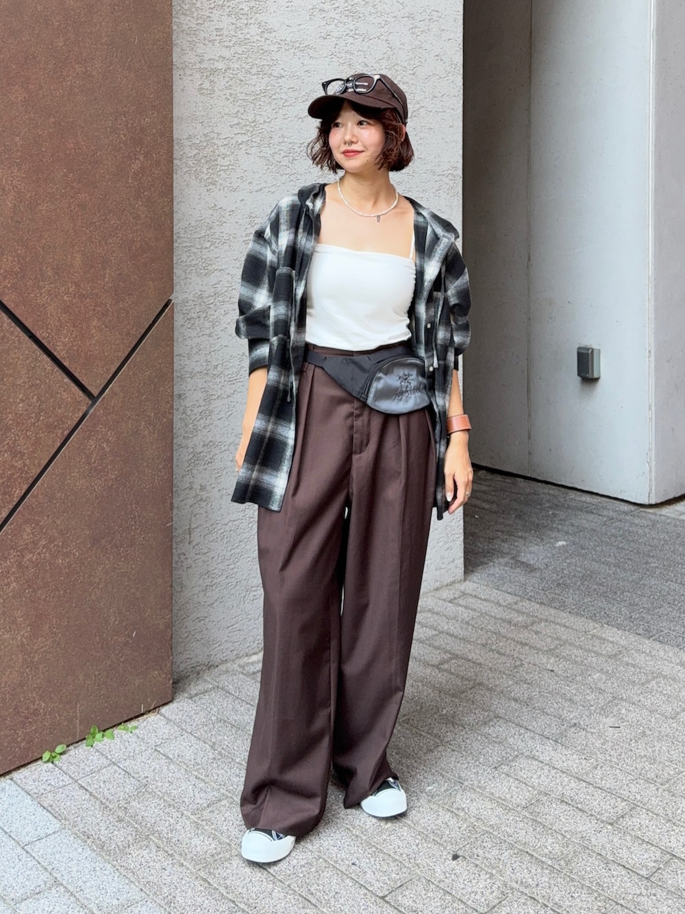ブラック系のシャツ/ブラウス、ブラウン系のスラックス、ブラック系のスニーカーを着用したレディースの夏コーディネートの2枚目の写真