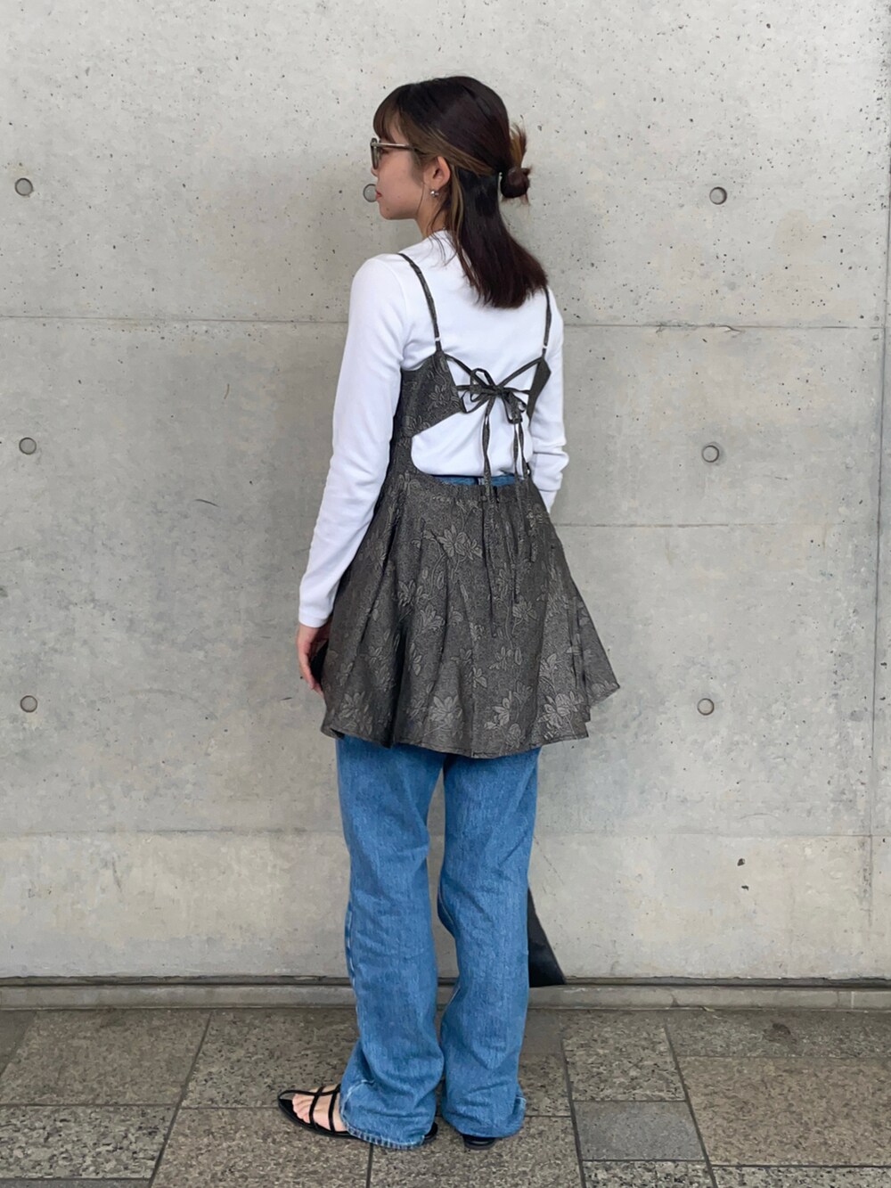 ブラック系のショルダーバッグ、ブラック系のサンダル、グレー系のキャミソールを着用したレディースの夏コーディネートの3枚目の写真