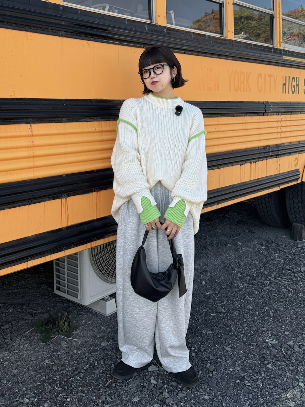 ホワイト系のニット/セーター、グレー系のその他パンツ、ブラック系のハンドバッグを着用したレディースの秋コーディネートの3枚目の写真