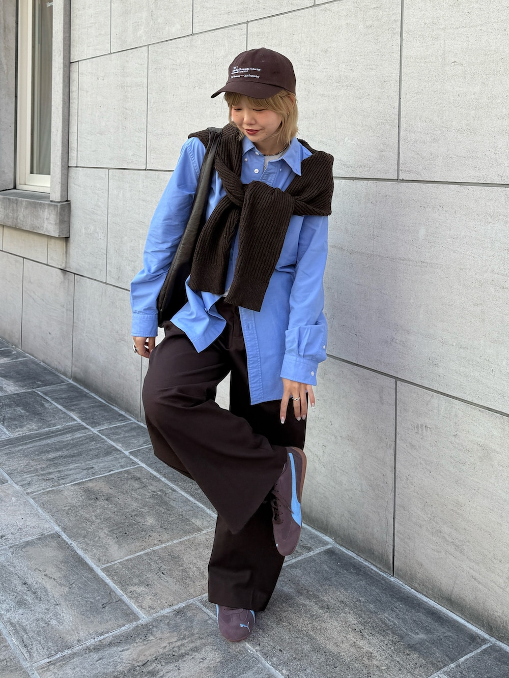 ブラウン系のニット/セーター、ブラウン系のショルダーバッグ、ブラウン系のスラックスを着用したレディースの春コーディネートの3枚目の写真