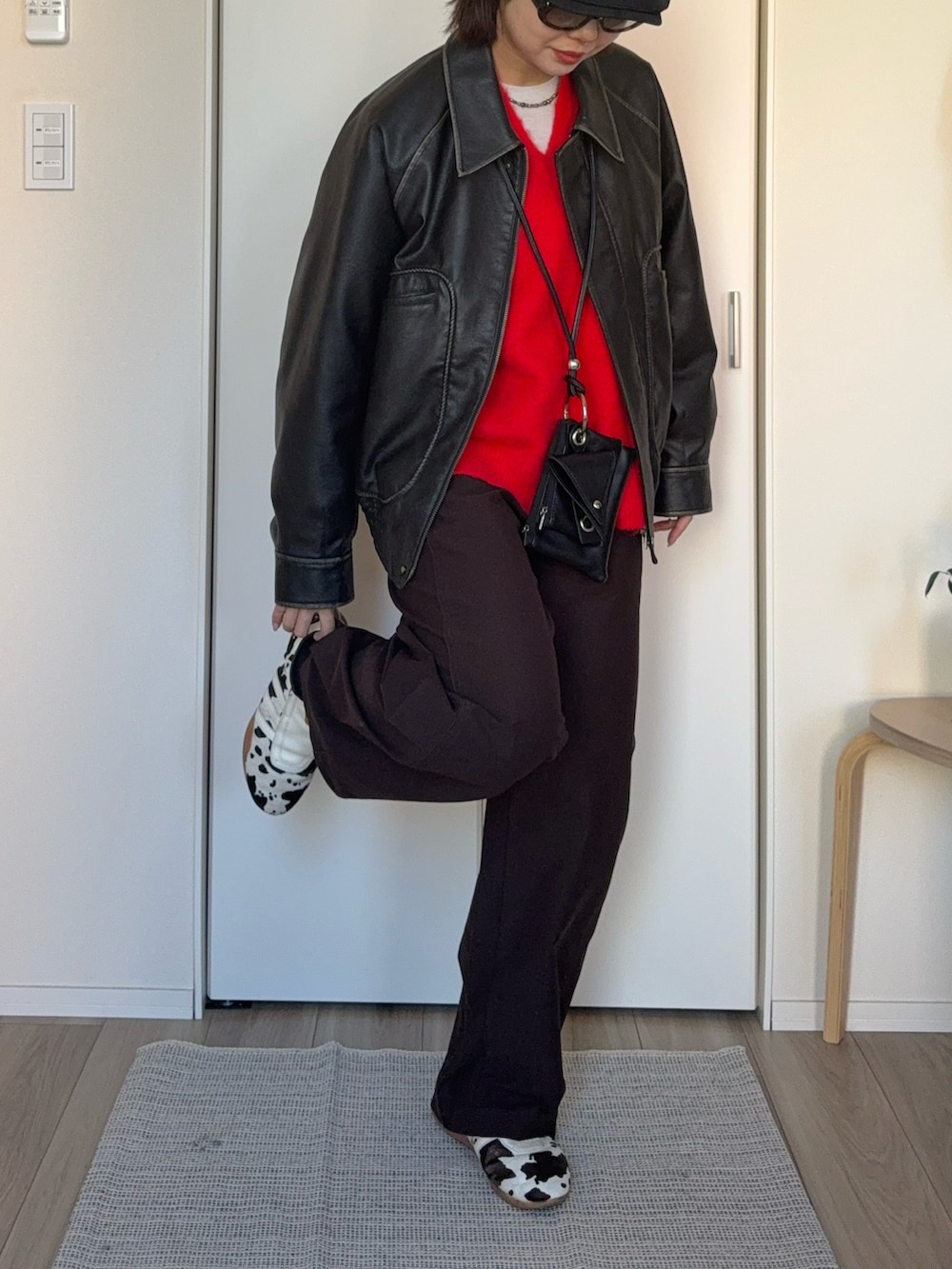 レッド系のニット/セーター、グレー系のブルゾン、ブラック系のショルダーバッグを着用したレディースの冬コーディネートの4枚目の写真