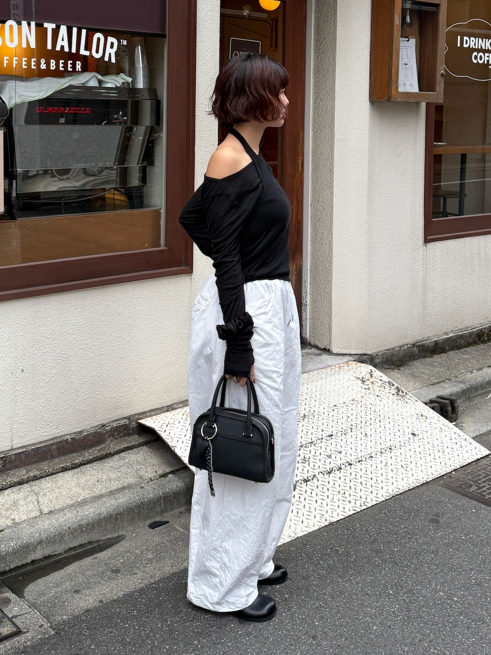 ブラック系のボストンバッグ、ブラック系のTシャツ/カットソー、ホワイト系のその他パンツを着用したレディースの秋コーディネートの4枚目の写真