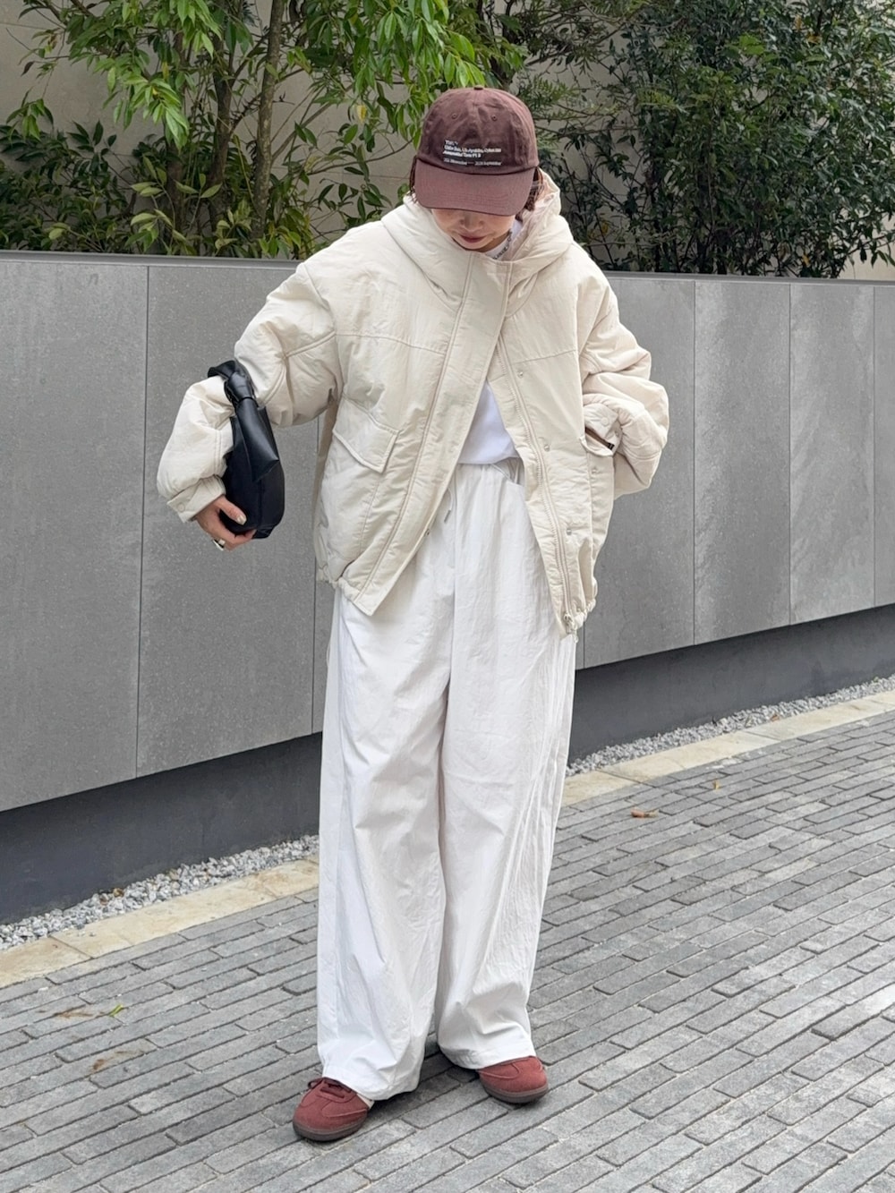 ホワイト系のブルゾン、ブラック系のハンドバッグ、ホワイト系のその他パンツを着用したレディースの秋コーディネートの2枚目の写真