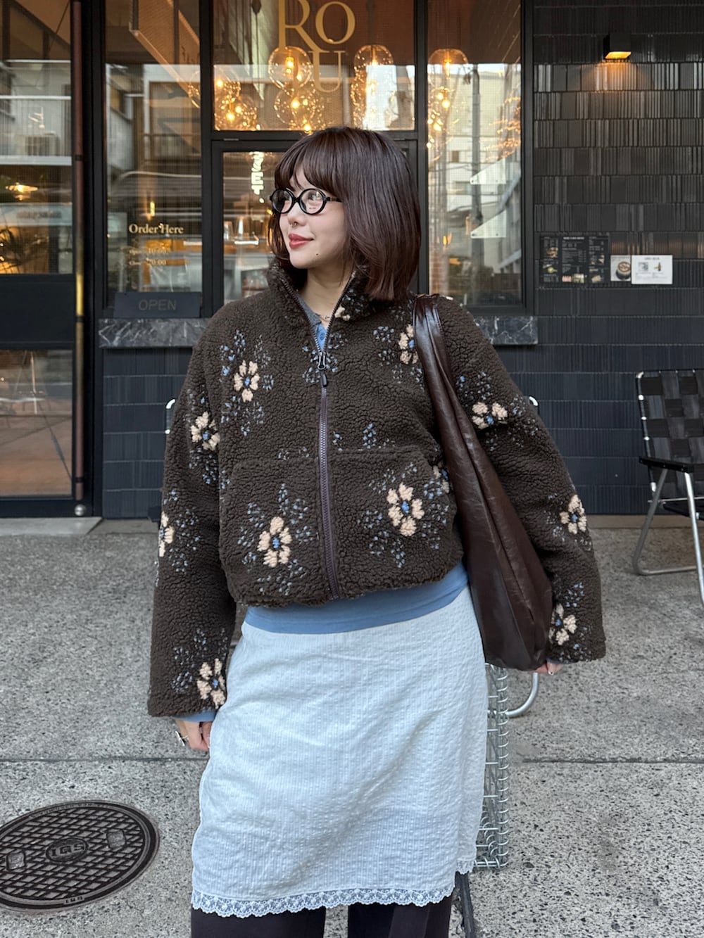 ブルー系のTシャツ/カットソー、ブラウン系のブルゾン、ホワイト系のスカートを着用したレディースの冬コーディネートの3枚目の写真