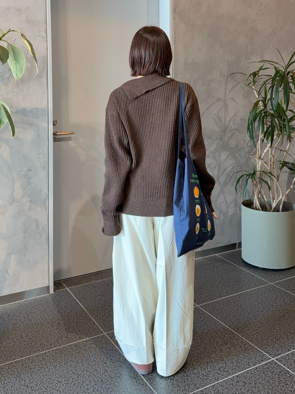 ブラウン系のニット/セーター、ホワイト系のスラックス、ブルー系のショルダーバッグを着用したレディースの冬コーディネートの3枚目の写真