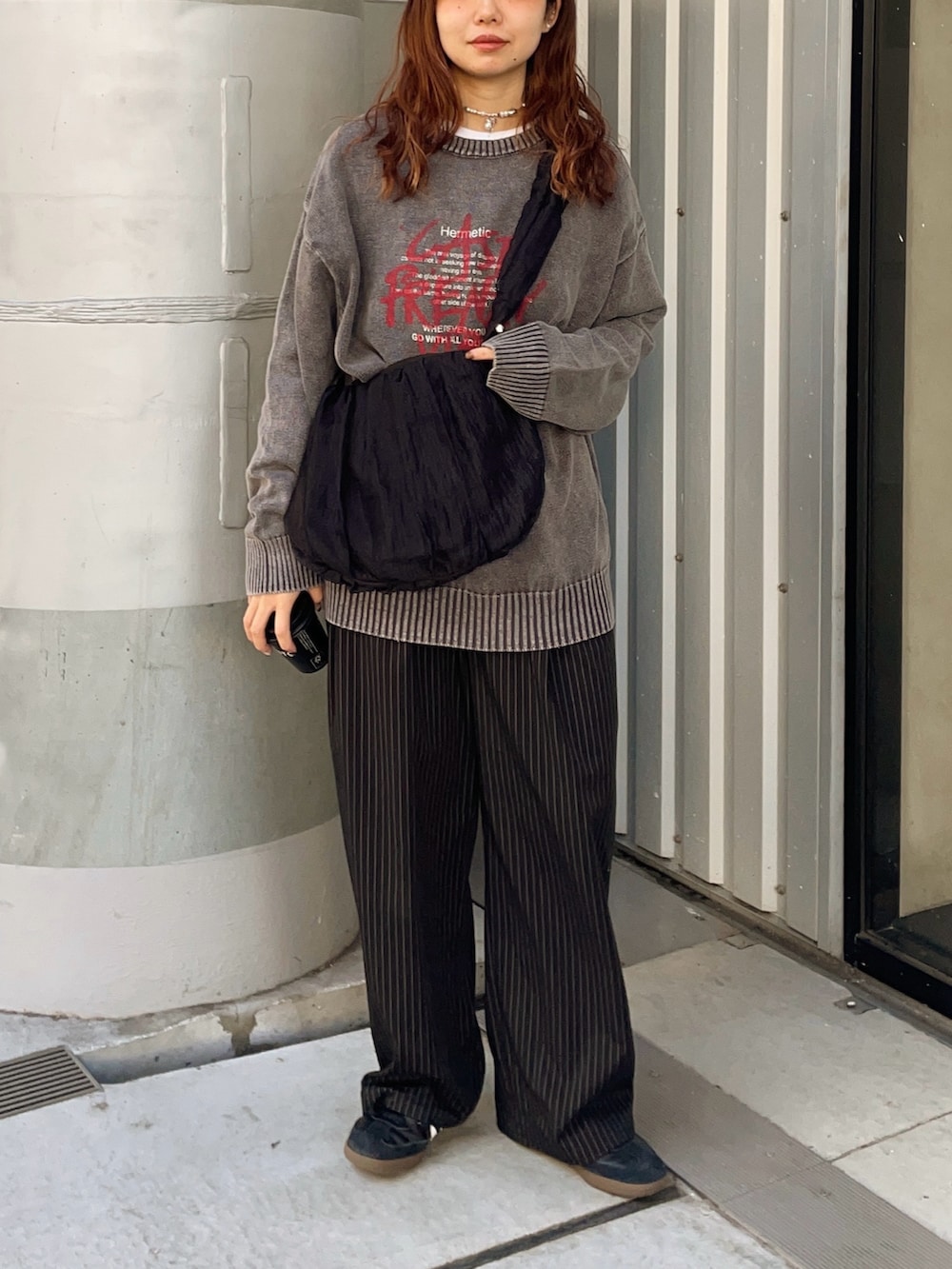 ブラック系のニット/セーター、ブラック系のショルダーバッグ、ブラック系のスラックスを着用したレディースの冬コーディネートの4枚目の写真