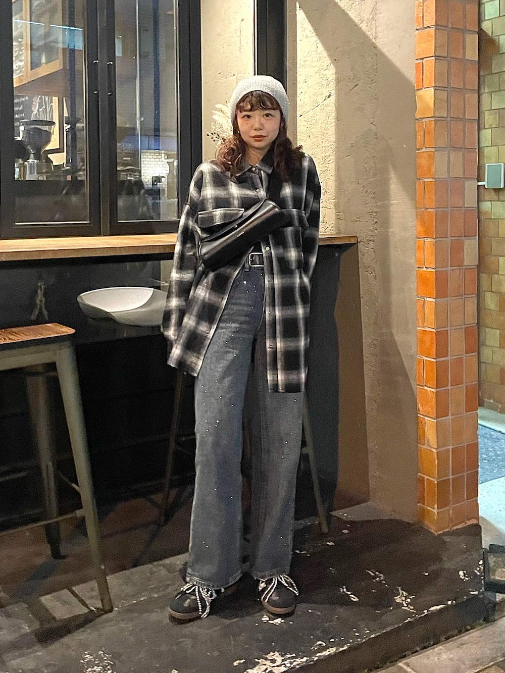 ブルー系のデニムパンツ、ブラック系のシャツ/ブラウス、ブラック系のショルダーバッグを着用したレディースの秋コーディネートの2枚目の写真