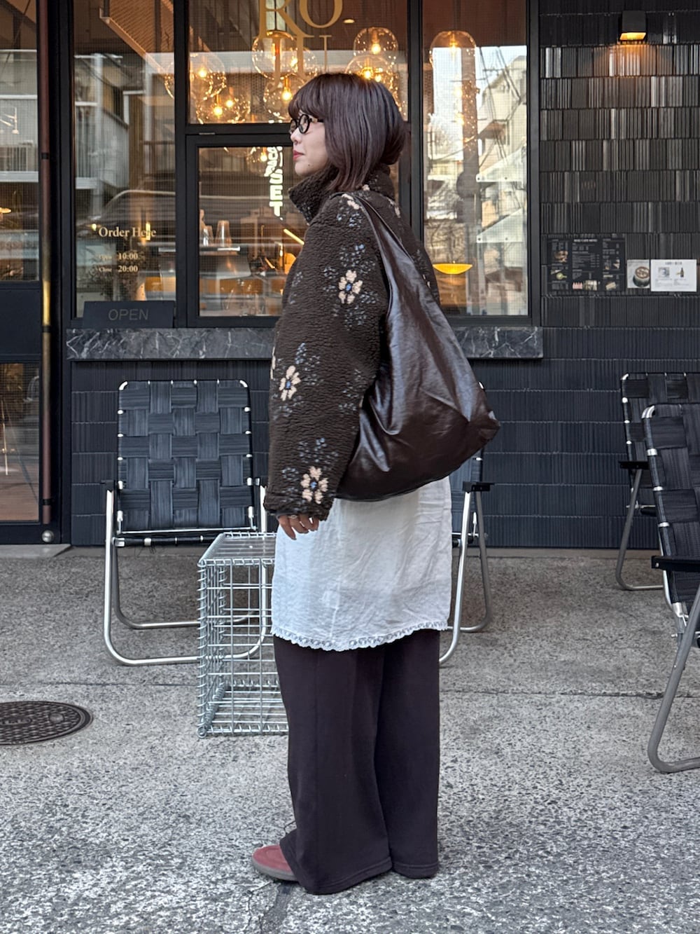 ブルー系のTシャツ/カットソー、ブラウン系のブルゾン、ホワイト系のスカートを着用したレディースの冬コーディネートの2枚目の写真