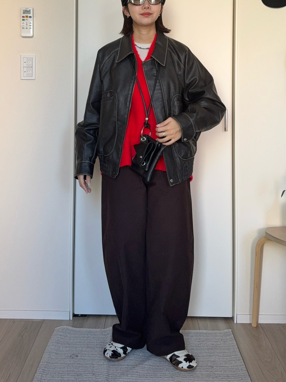 レッド系のニット/セーター、グレー系のブルゾン、ブラック系のショルダーバッグを着用したレディースの冬コーディネートの3枚目の写真