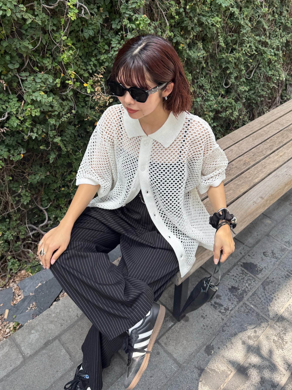 ブラック系のスラックス、ホワイト系のシャツ/ブラウス、ブラック系のショルダーバッグを着用したレディースの夏コーディネートの5枚目の写真