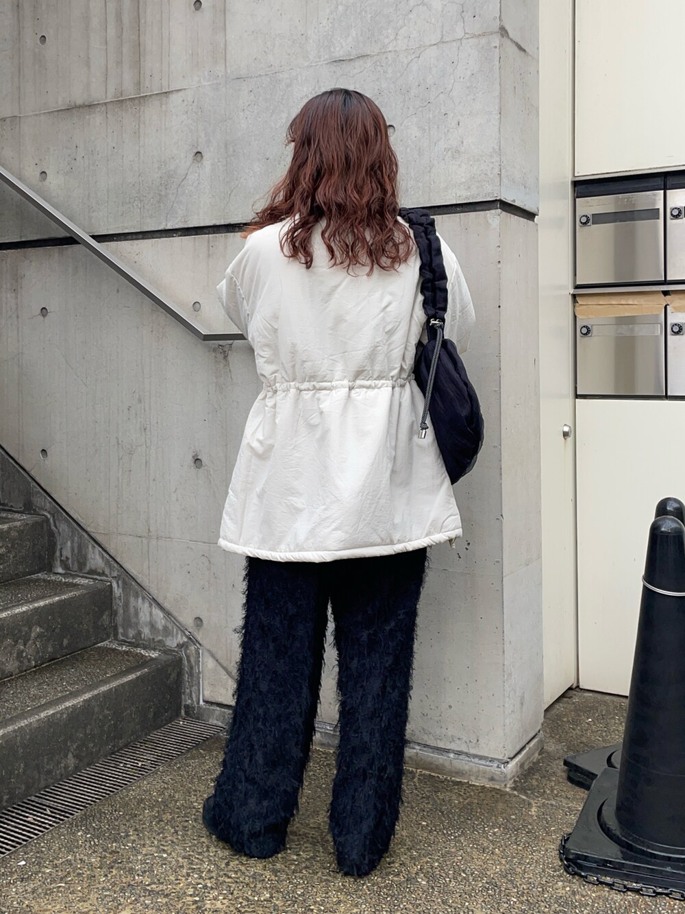 ブラック系のショルダーバッグ、ホワイト系のブルゾン、グレー系のTシャツ/カットソーを着用したレディースの冬コーディネートの4枚目の写真