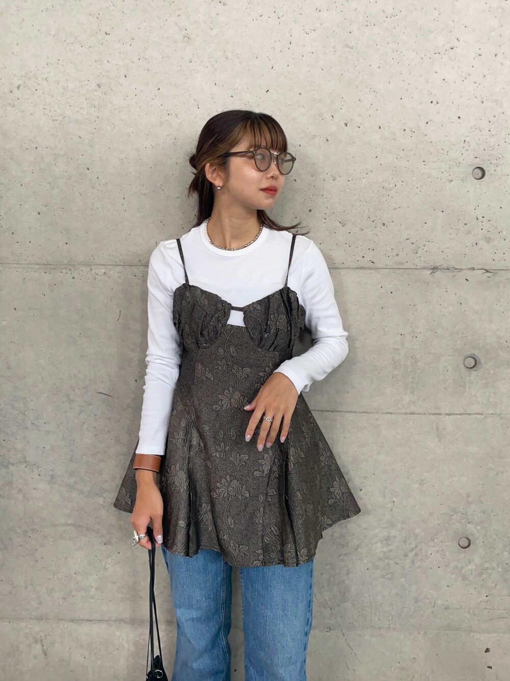 ブラック系のショルダーバッグ、ブラック系のサンダル、グレー系のキャミソールを着用したレディースの夏コーディネートの2枚目の写真