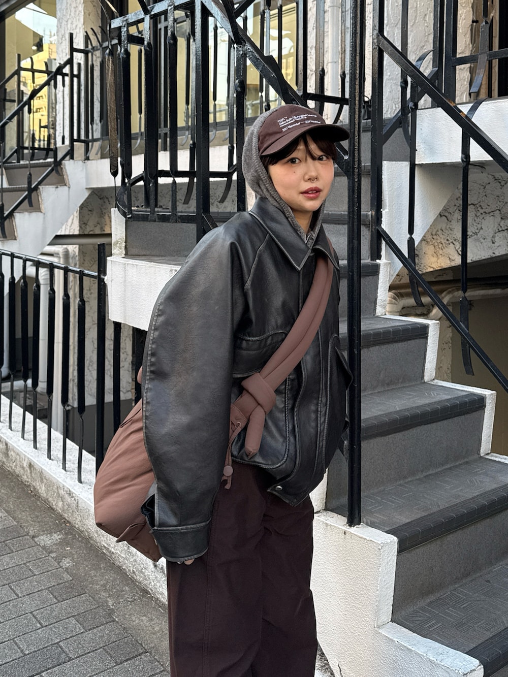 グレー系のパーカー、グレー系のブルゾン、ブラウン系のハンドバッグを着用したレディースの冬コーディネートの5枚目の写真