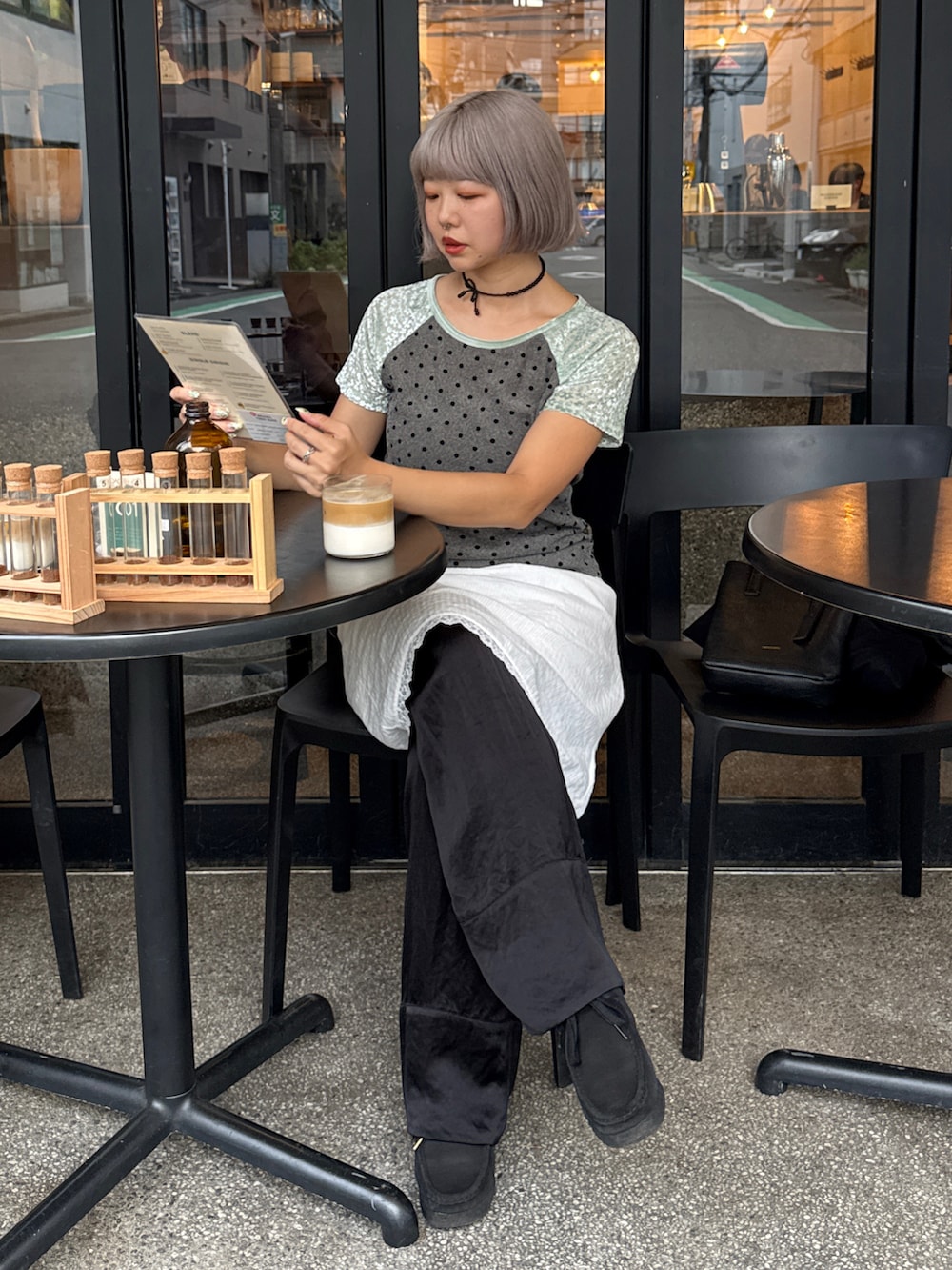 グリーン系のTシャツ/カットソー、ブラック系のその他パンツ、ホワイト系のスカートを着用したレディースの秋コーディネートの3枚目の写真