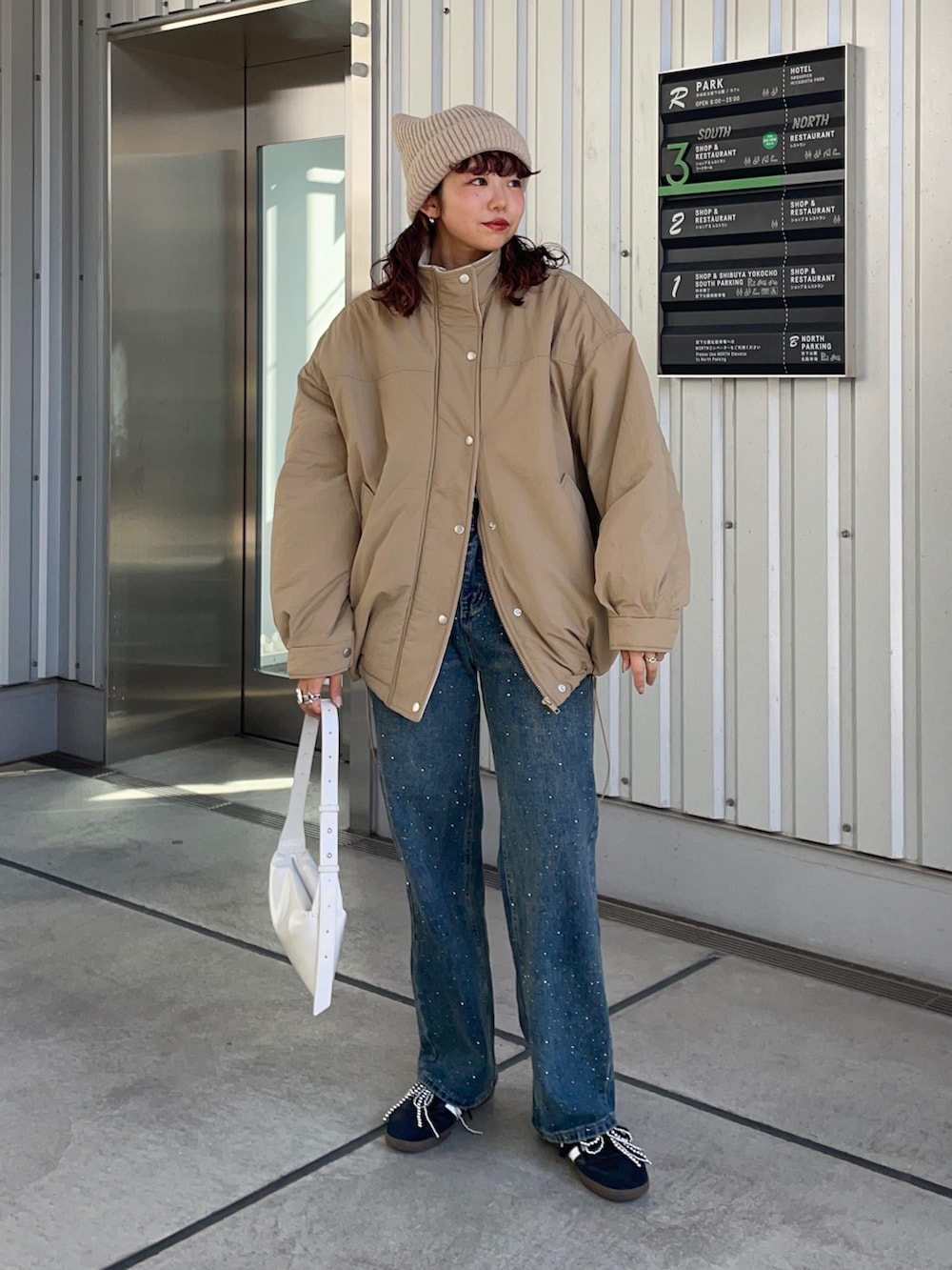 ベージュ系のブルゾン、ブルー系のデニムパンツ、シルバー系のシューズ小物/雑貨を着用したレディースの秋コーディネートの2枚目の写真