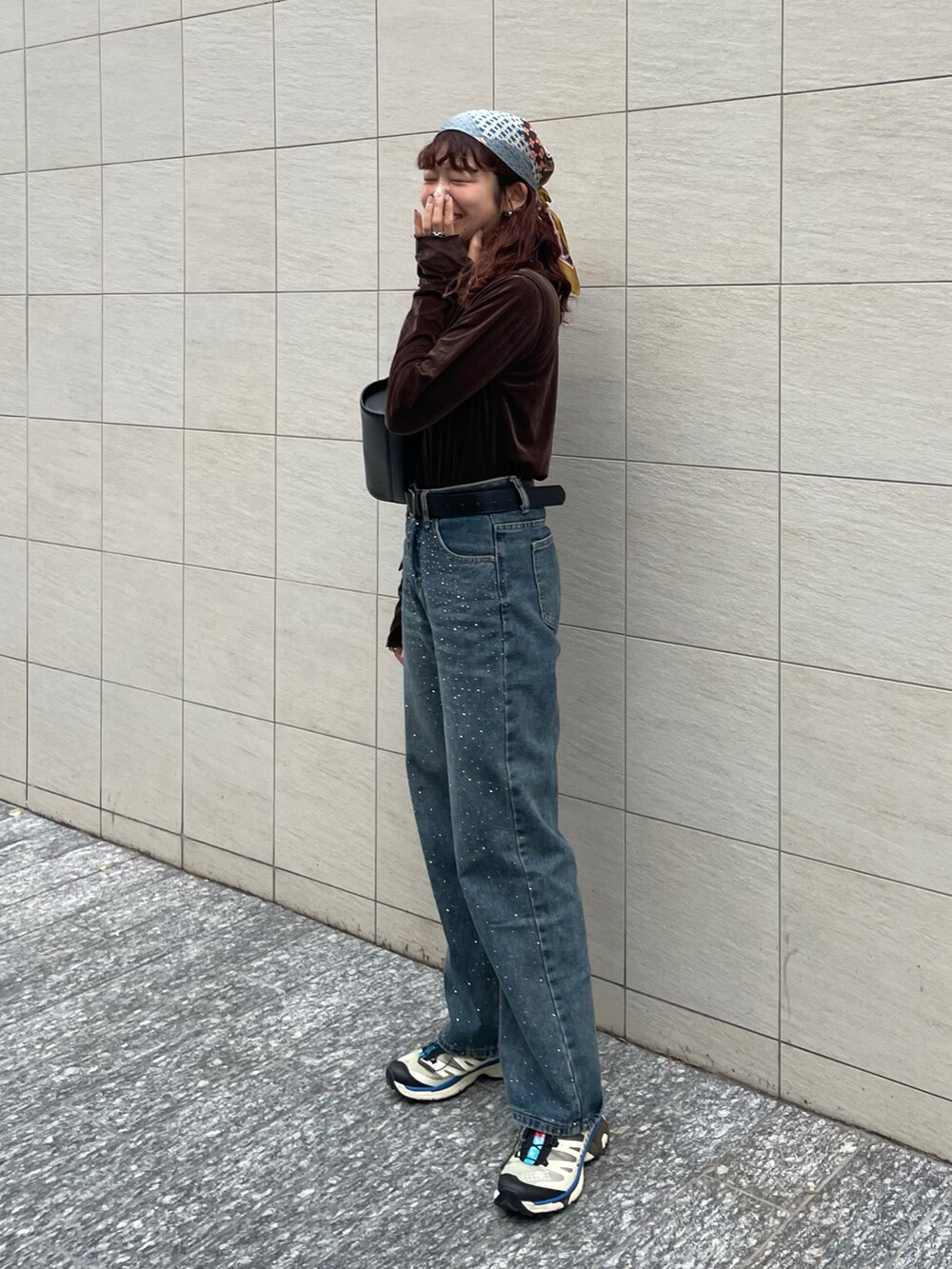 ブラウン系のTシャツ/カットソー、ブラック系のショルダーバッグ、ブルー系のデニムパンツを着用したレディースの秋コーディネートの5枚目の写真