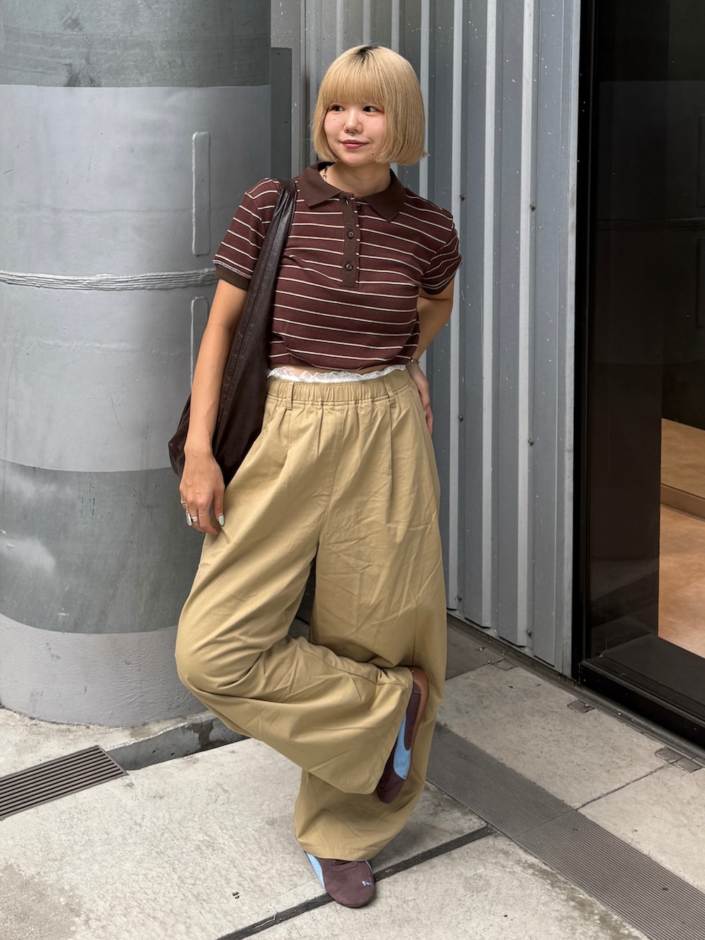 ベージュ系のその他パンツ、ブラウン系のショルダーバッグ、ブラウン系のポロシャツを着用したレディースの夏コーディネートの3枚目の写真