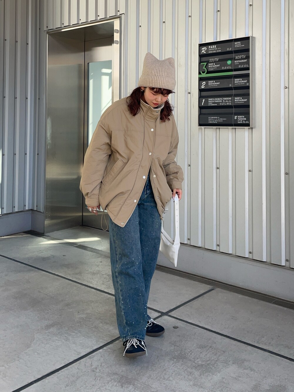 ベージュ系のブルゾン、ブルー系のデニムパンツ、シルバー系のシューズ小物/雑貨を着用したレディースの秋コーディネートの4枚目の写真
