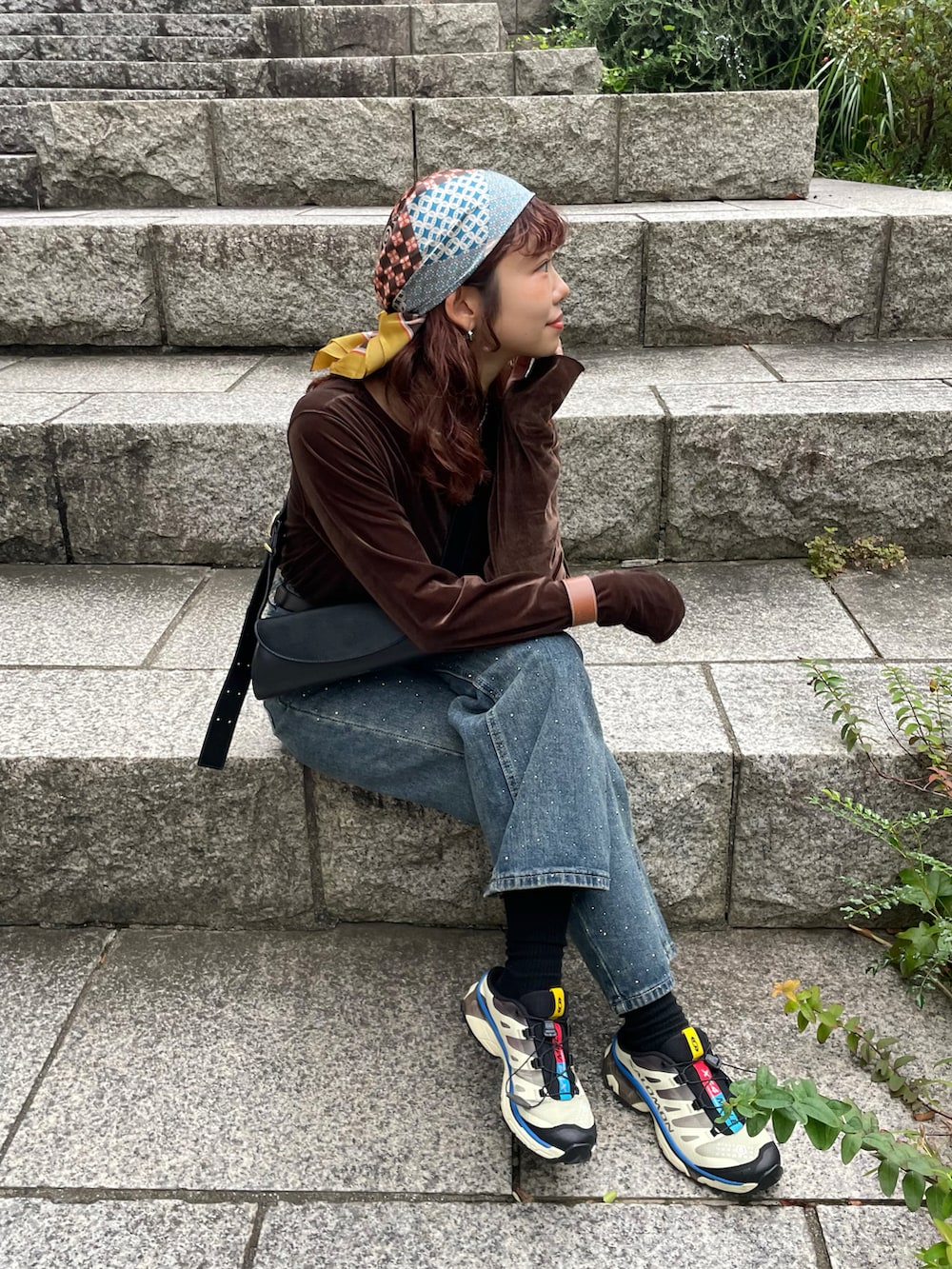 ブラウン系のTシャツ/カットソー、ブラック系のショルダーバッグ、ブルー系のデニムパンツを着用したレディースの秋コーディネートの4枚目の写真