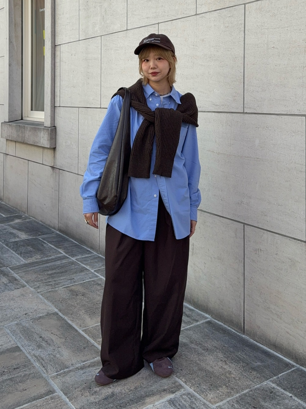 ブラウン系のニット/セーター、ブラウン系のショルダーバッグ、ブラウン系のスラックスを着用したレディースの春コーディネートの4枚目の写真