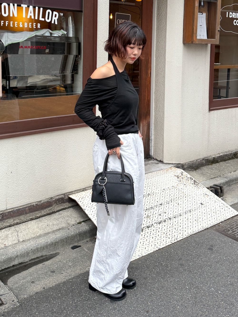 ブラック系のボストンバッグ、ブラック系のTシャツ/カットソー、ホワイト系のその他パンツを着用したレディースの秋コーディネートの2枚目の写真