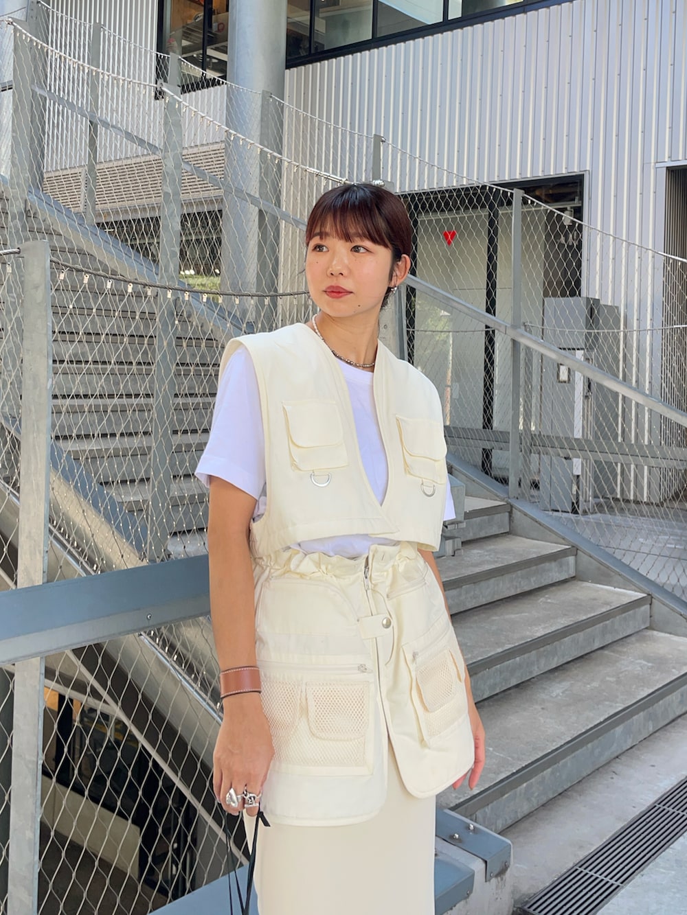 ホワイト系のベスト、ホワイト系のスカート、ブラック系のブーツを着用したレディースの秋コーディネートの3枚目の写真