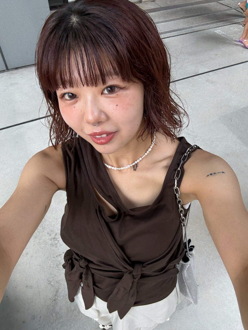 ブラウン系のTシャツ/カットソー、ベージュ系のスラックス、ホワイト系のスニーカーを着用したレディースの夏コーディネートの5枚目の写真
