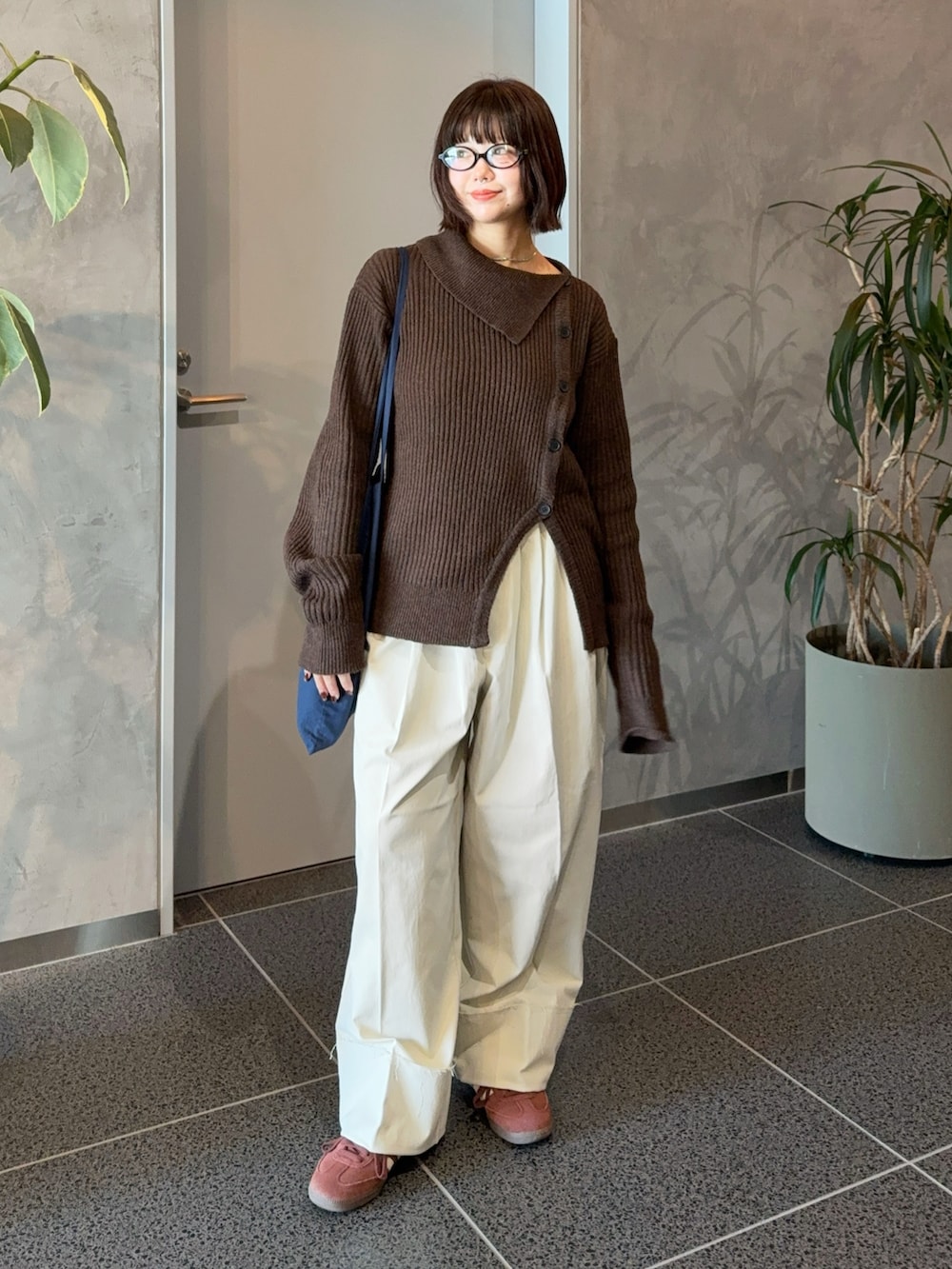 ブラウン系のニット/セーター、ホワイト系のスラックス、ブルー系のショルダーバッグを着用したレディースの冬コーディネートの5枚目の写真