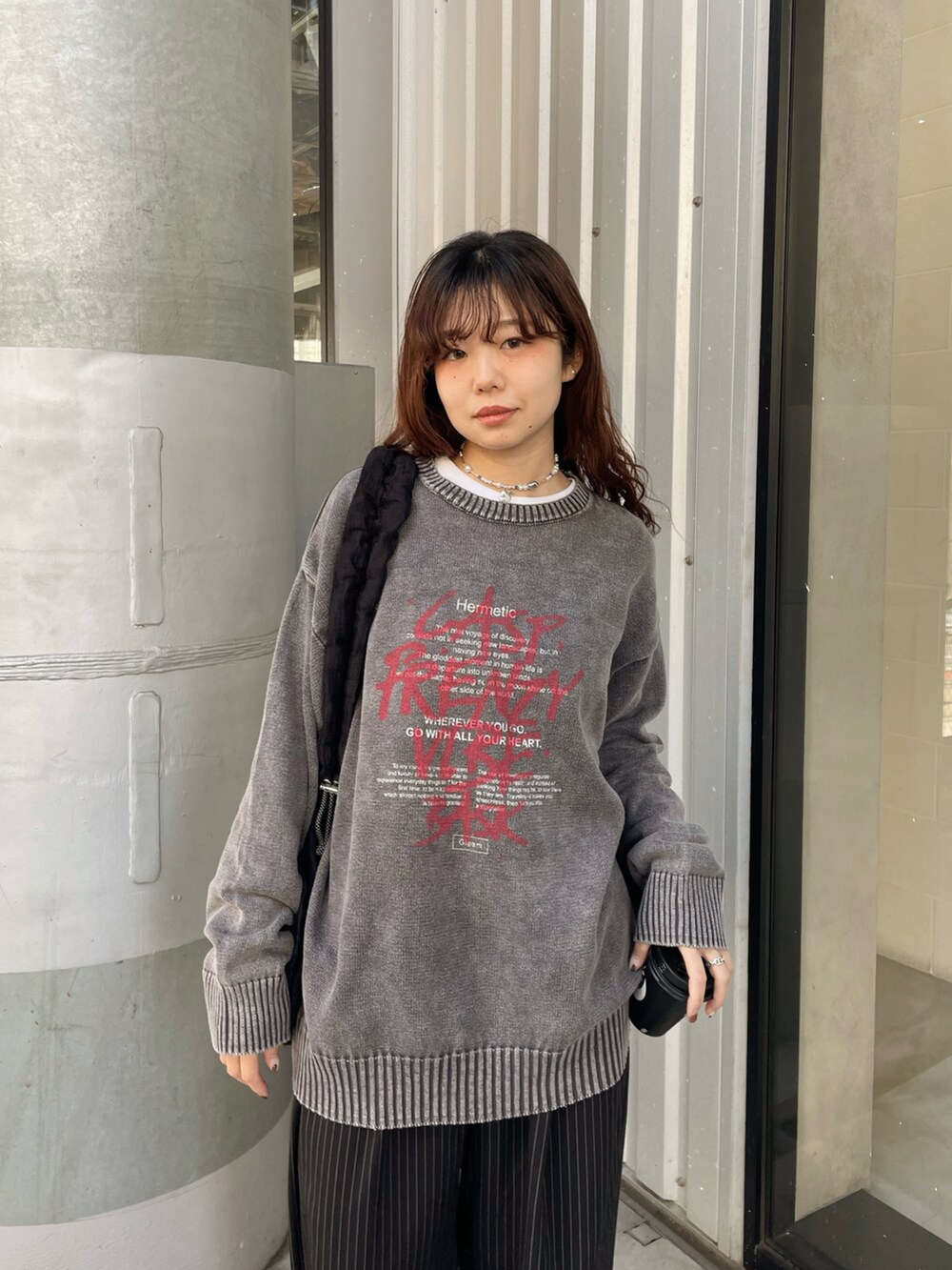 ブラック系のニット/セーター、ブラック系のショルダーバッグ、ブラック系のスラックスを着用したレディースの冬コーディネートの5枚目の写真